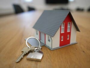 Model house attached as a key ring on a set of keys laying on op of a table